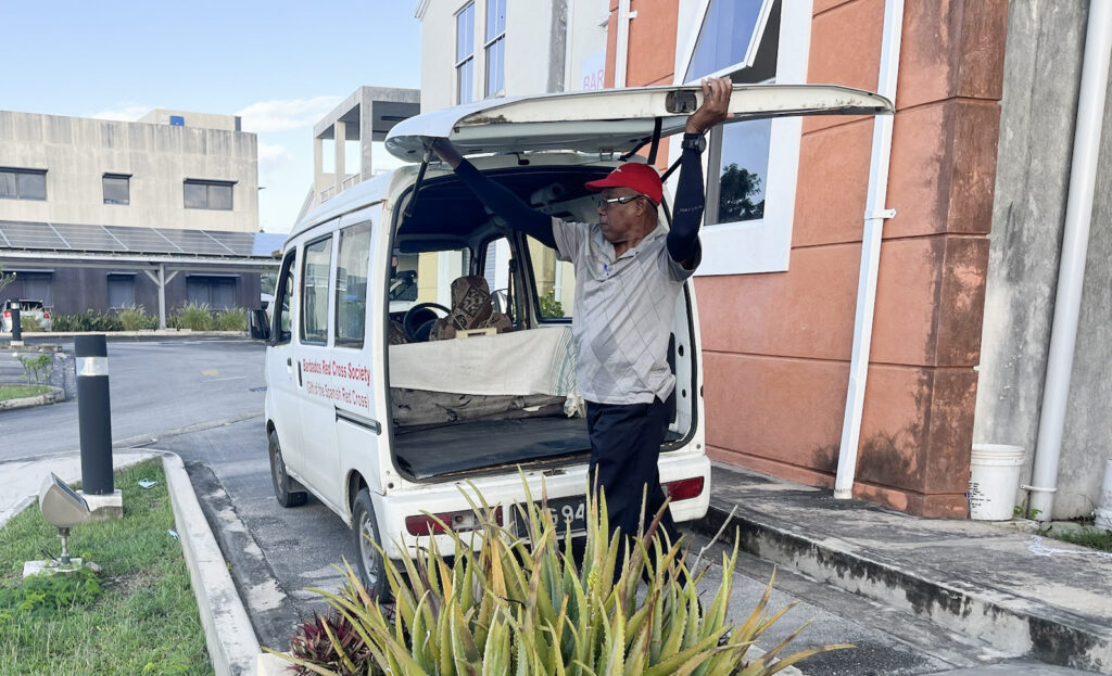 Image of a man lifting the rear gate of the meals on wheels van.